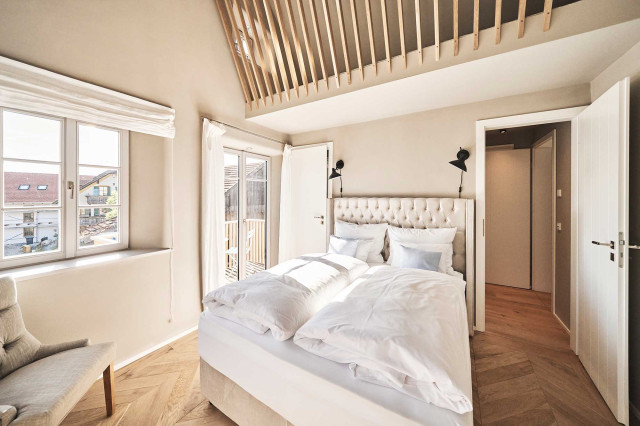 Das Flachshaus Ferienhaus - Schlafzimmer mit Chesterfield Boxspringbett, gestärkter, weißer Bettwäsche, Eiche-Fischgrätparkett, Sprossenfenstern mit Leinenvorhängen und Schlafempore mit Holzlamellen (Photo 43)