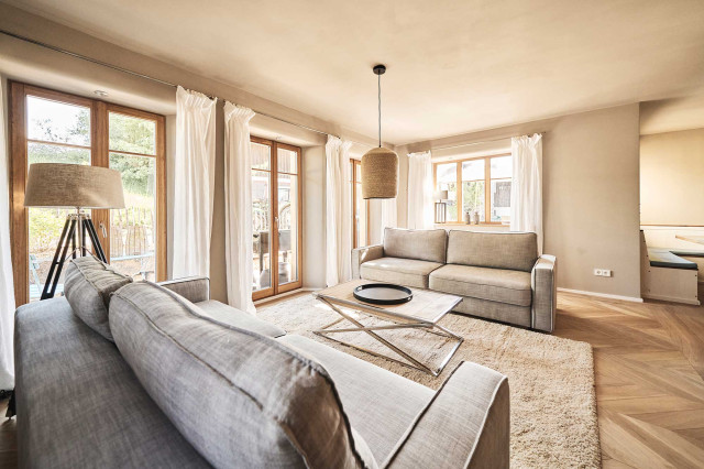 Das Flachshaus Ferienhaus - Wohnzimmer mit zwei hellgrauen Sofas auf flauschigem hellen Teppich (Photo 7)