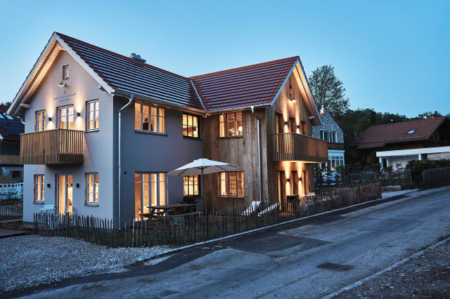 Das Flachshaus Ferienhaus - Ferienhaus mit Holzfassade, modernen Holzbalkonen und Sprossenfenstern in Abendstimmung mit warmer Außen- und Innenbeleuchtung (Photo 49)