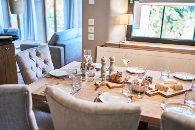 Boutique Apartment Bergfreuden - Gedeckter Tisch mit massiver heller Eichenholztischplatte, handgefertigten helltürkisenen Kermiktellern, langstieligen Weingläsern, Kristallwassergläser, Pfeffer- und Salzmühle, Brotzeitbrett mit Käse, frischem Brot und Oliven. (Photo 27)