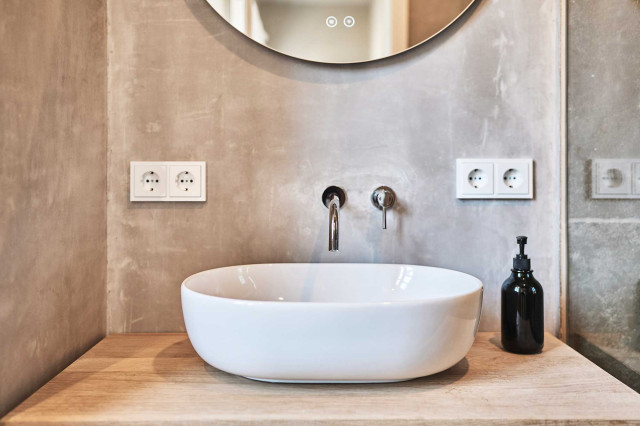 Boutique Apartment Flachsblüte - Badezimmer mit natürlichem Kalkputz gespachtelter Wand, rundem Badspiegel und einem Waschtisch aus hellem Eichenholz mit weißem, ovalem Keramikwaschbecken (Photo 34)