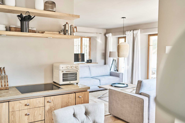 Das Flachshaus Ferienhaus - offener Koch-Ess-Wohnbereich mit Natursteinarbeitsplatte und Leinenvorhaengen (Photo 2)