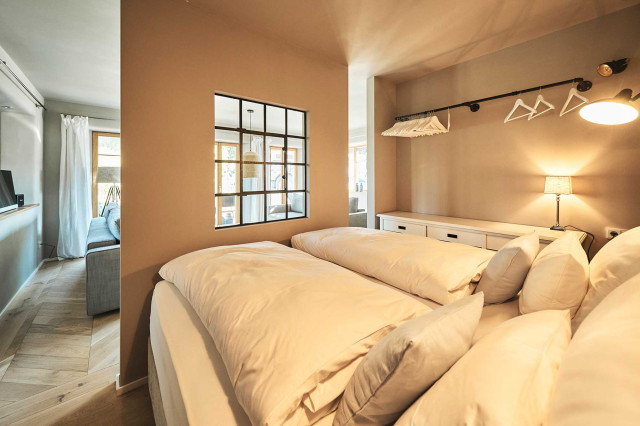 Das Flachshaus Ferienhaus - Raumteiler mit schwarzem Stahlfenster trennt Schlafbereich von Wohnzimmer (Photo 6)